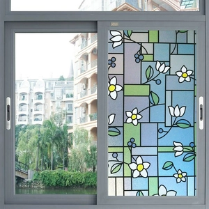 Detail of stained glass privacy film showing floral patterns and frosted texture on window