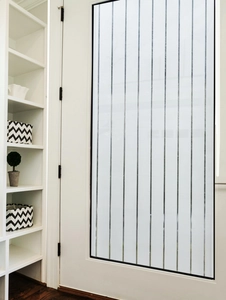 Vertical striped frosted privacy glass film on modern white frame door in home setting