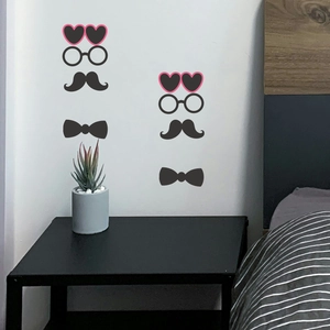Pegatinas de pared con pajaritas y gafas negras en una pared blanca de dormitorio