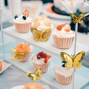 Detailed view of 3D gold butterfly decorations on a cake with hollow carved patterns