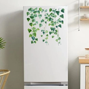 Macro detail of watercolor green vine wall stickers applied on a white refrigerator