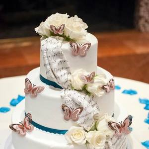 Detailed view of 3D rose gold hollow butterfly stickers on a white wedding cake