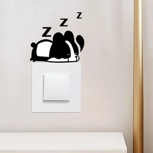 Détail d'un autocollant mural chiot endormi décorant un interrupteur d'éclairage
