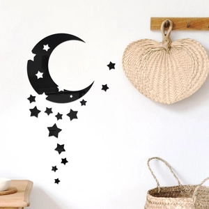 Detail view of 3D black acrylic moon and star mirror wall stickers on a white bedroom wall