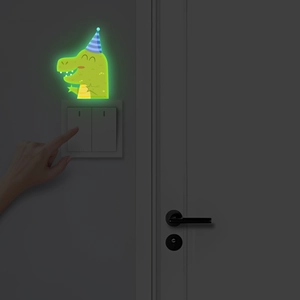 Glow in the dark green dinosaur wall sticker with party hat above a light switch