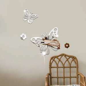Détail de stickers muraux papillons en acrylique effet miroir sur un mur beige doux