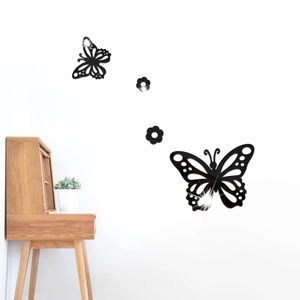 Détail des stickers muraux papillons en acrylique noir avec effet miroir sur un mur blanc