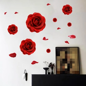 Detail of vivid 3D red rose wall stickers and scattered petals on a white wall