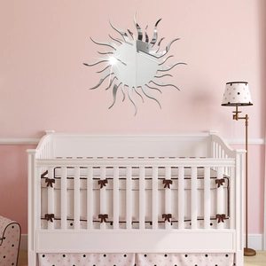 Macro shot of sunburst acrylic mirror wall sticker above a white baby crib in nursery