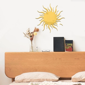 Golden sun acrylic mirror wall sticker on white wall above a bedroom nightstand