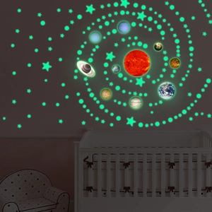 Glow-in-the-dark solar system wall stickers with stars and planets in a dark nursery room