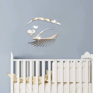 Silver acrylic mirror eye and heart wall sticker above a white baby crib in nursery