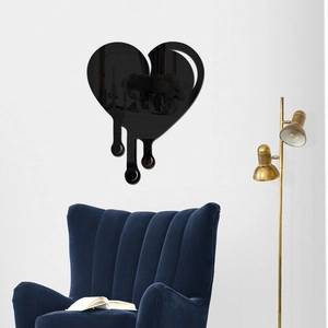 Detail of a black dripping heart mirror wall sticker in a modern living room setting