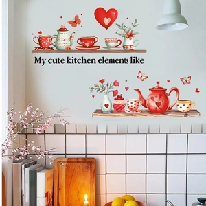 Détail de stickers muraux avec théières rouges et cœurs sur un mur de cuisine blanc