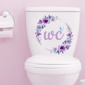Dettaglio adesivo floreale per WC con rose viola su sciacquone in ceramica bianca per bagno