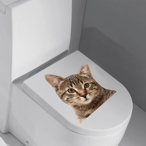 3D realistic brown tabby cat wall decal on a toilet lid with a creative peephole design
