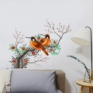 Detail view of bird on branch wall sticker in a cozy bedroom scene above headboard