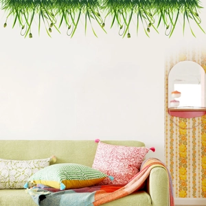 Hanging green vine wall decals decorating a white wall above a cozy light green sofa