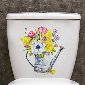 Detail of floral watering can sticker with pink peonies on white ceramic toilet tank