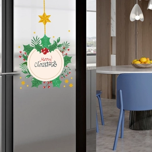 Detailed view of Merry Christmas wall sticker with holly leaves on kitchen glass door