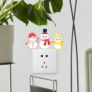 Detailed view of snowman wall decals applied around a white light switch for decor