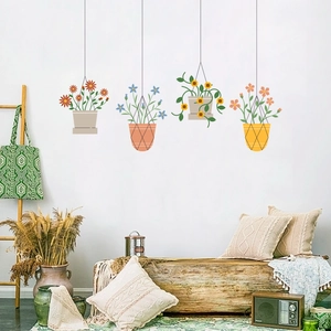 Detail of four hanging potted plant wall stickers featuring colorful floral designs on a white wall
