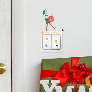 Detail view of festive Christmas switch stickers with elf and gingerbread man on white wall