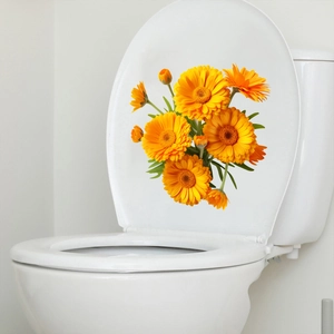 Detail of vibrant yellow floral decals applied to a white ceramic toilet lid