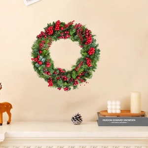 Couronne de Noël festive avec aiguilles de pin vertes et baies rouges sur un mur