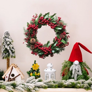 Christmas wreath with red berries, pine cones and green leaves for festive wall decoration