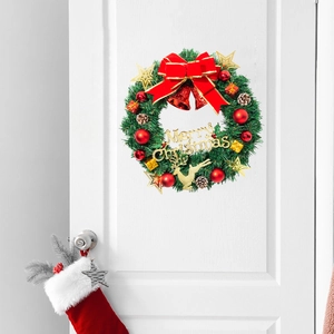 Christmas pine needle wreath with red bow and gold reindeer on a white interior door