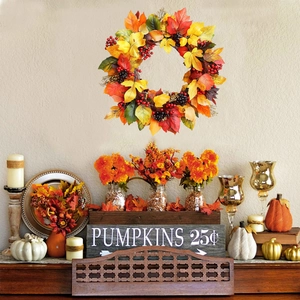 Fall autumn wreath with colorful maple leaves and red berries on a minimalist white wall