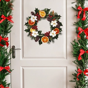 Christmas wall sticker with orange slices pinecones and red berries on a white door