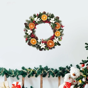 Christmas wreath with orange slices, red berries, and pine cones on white background