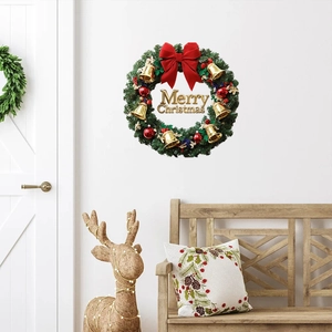 Close-up of Christmas wreath with golden bells, red bow, and Merry Christmas sign