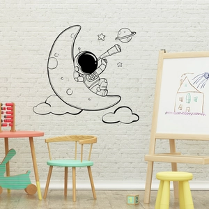 Detailed view of astronaut moon wall stickers in a cozy nursery room setting