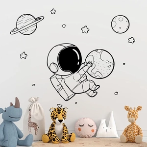 Stickers muraux astronaute noir minimalistes dans un décor de chambre d'enfant douce