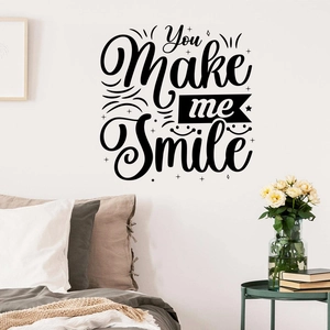 Detail of 'You Make me Smile' wall decal in a cozy bedroom above a white headboard