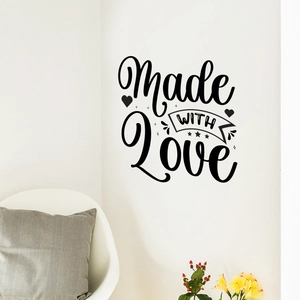 Detail of black 'Made WITH Love' vinyl wall sticker in a cozy home interior setting