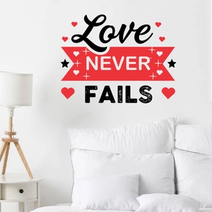 Détail du sticker mural Love Never Fails avec cœur rouge dans une chambre à coucher