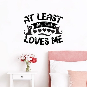 Detail of artistic black wall decal AT LEAST My Cat LOVES ME with feline silhouettes