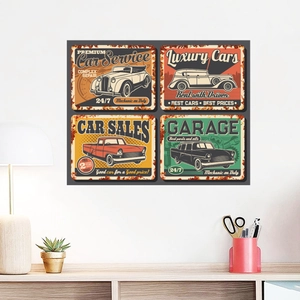 Set of four vintage car theme metal wall plaques styled on a white wall above a wooden desk