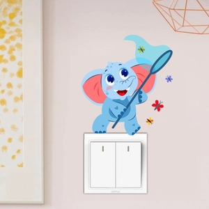 Détail d'un mignon autocollant éléphant bleu avec filet à papillons sur un interrupteur