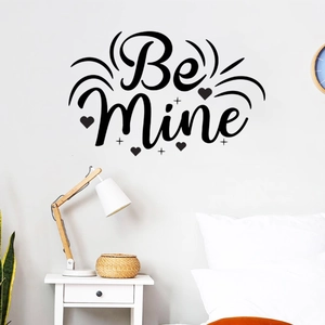 Detail of Be Mine black vinyl wall sticker with heart accents on a white bedroom wall