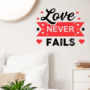 Détail du sticker mural Love Never Fails avec cœurs rouges dans une chambre à coucher