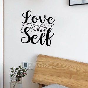 Detail of Love YOUR Self vinyl wall decal with heart accents on a white wall
