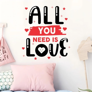 Détail de sticker mural All You Need Is Love avec des cœurs rouges sur mur blanc