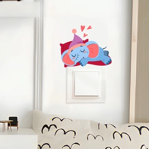 Détail d'un sticker mural éléphant bleu dormant au-dessus d'un interrupteur blanc