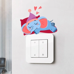 Gros plan d'un autocollant d'éléphant bleu endormi décorant un interrupteur mural