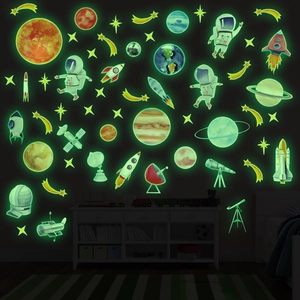 Glow-in-the-dark astronaut and rocket wall stickers creating a starry space theme in a dark room
